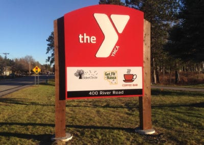 lighted outdoor signs for the YMCA. The sign is red and on wooden posts.