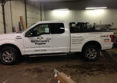 vinyl vehicle sign on door and bed of white pickup truck for North Country Propane
