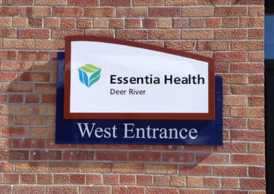 vinyl signs on Brick building advertising the West Entrance of Essentia Health in Deer River