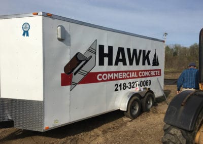 red and black vinyl sign on white trailer for Hawk Commercial Concrete