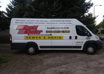 vinyl vehicle sign on white van the sign is for Rapid Rooter and is red, black and yellow